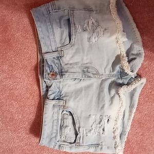 Light blue ripped denim shorts with patterned trim